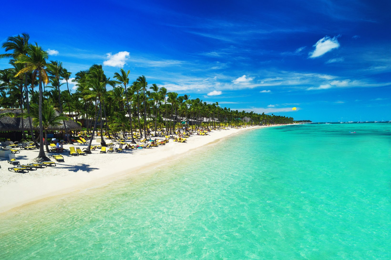 Tropical vacation in Punta Cana, Dominican Republic. Aerial view over beach resort. Parasailing. Sunbathing